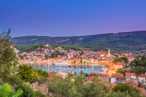 Elevated view on the town of Jelsa, Hvar (Croatia) at dusk. The regular ferry ship waiting in the harbour