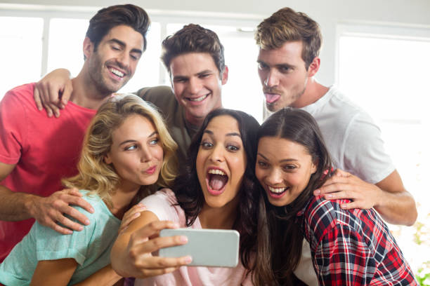 istock Happy friends making faces while taking selfie at home 674370886