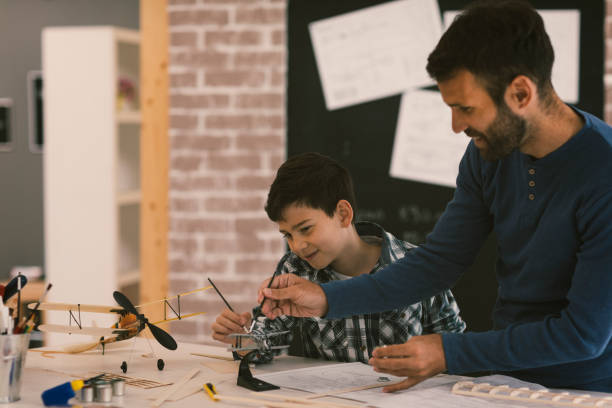 istock Father and son making toy plane 674381474