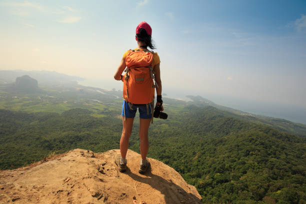 istock successful woman photographer on mountain peak cliff 674384490