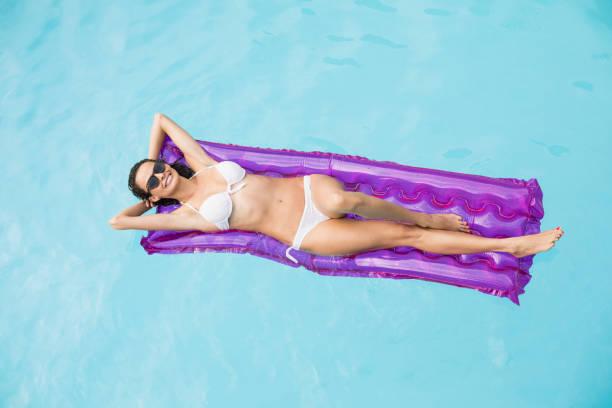 istock Beautiful woman relaxing on inflatable raft 674387716