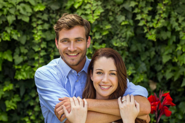 istock Portrait of couple hugging at front yard 674388466