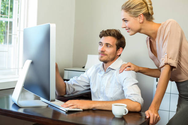 istock Happy man and woman discussing while working on computer at office 674396720
