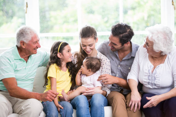 istock Smiling family with baby while sitting on sofa 674400596