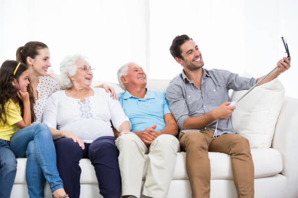 istock Smiling family taking self portrait while sitting on sofa 674400730