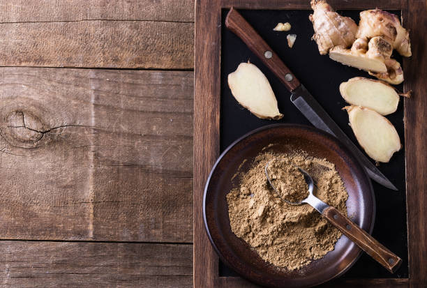 istock Top view of ground ginger over rustic wooden background 674400972