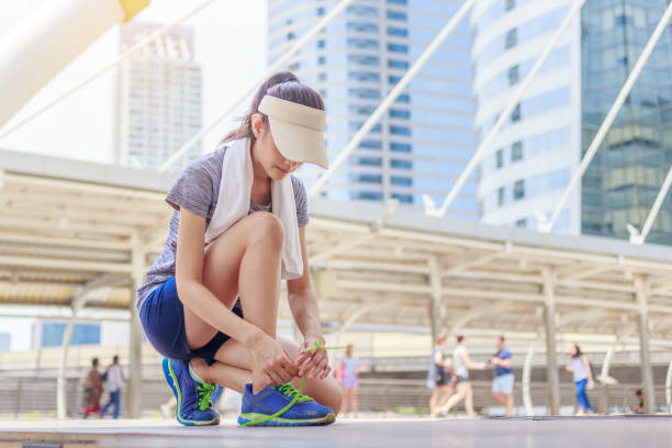 Beautiful girl tying shoe laces before running outdoors Beautiful girl tying shoe laces before running outdoors. Female sport fitness runner. toms shoes stock pictures, royalty-free photos & images