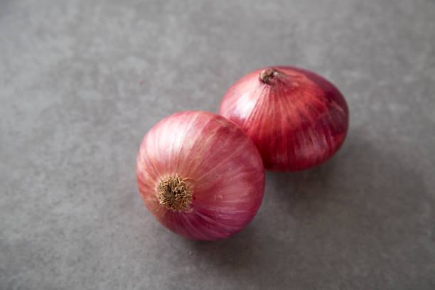 istock Red onions on Gray granite slab 674407276