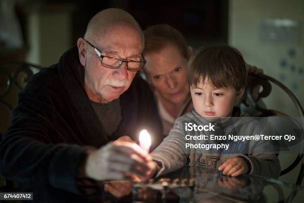 Famiglia Ebraica Che Accende Candele Hanukkah In Una Menorah Per Le Vacanze - Fotografie stock e altre immagini di Giudaismo