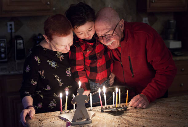 famille juive avec granparents et petit-fils d’éclairage hanukkah bougies une menorah pour les vacances - menorah hanukkah israel judaism photos et images de collection