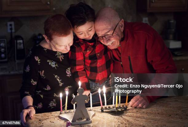 Foto de Família Judia Com Granparents E Neto Iluminando Velas Em Uma Menorá Para As Férias e mais fotos de stock de Família