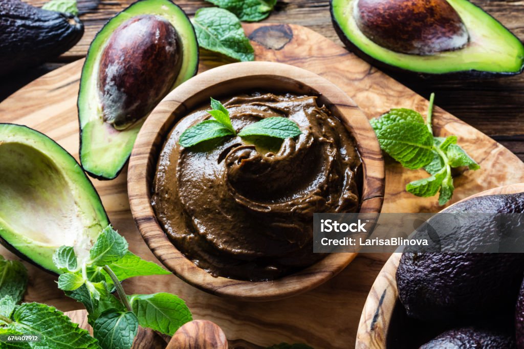 Rohe Schokolade Avocadomousse Pudding mit Minze in Olivenöl Holzschale. Vegan-vegetarisches Essen. Bio gesundes Dessert. - Lizenzfrei Avocado Stock-Foto