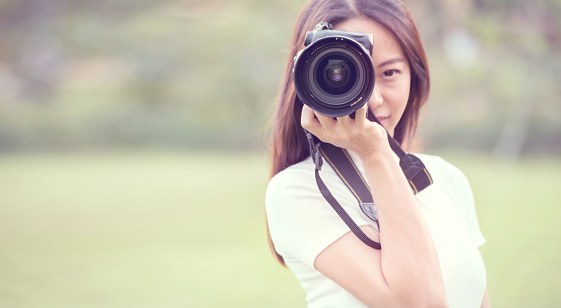 Woman is a professional photographer with dslr camera, outdoor, Portrait, copy space.
