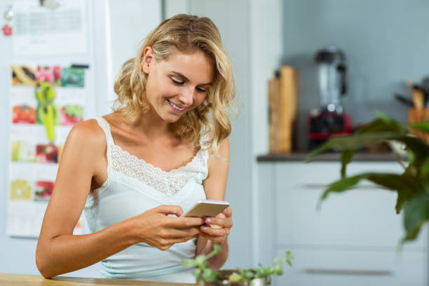 istock Beautiful woman holding mobile phone 674410520