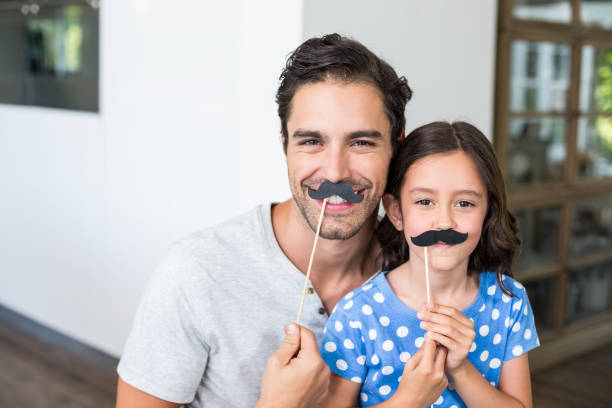 istock Smiling father and daughter with artificial mustache 674417514