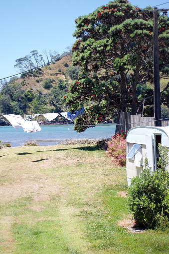 Washing dries beside a caravan on the Sea. A Quintessential Kiwi Holiday image.