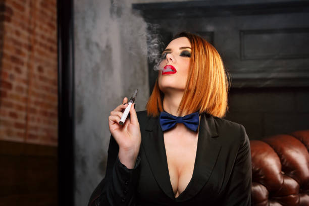 팜므 파탈과 전자 담배 - smoking women kitsch bow tie 뉴스 사진 이미지
