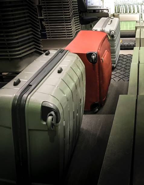istock Gray And Red  Suitcases  Are Loaded On Black Belt 674420790
