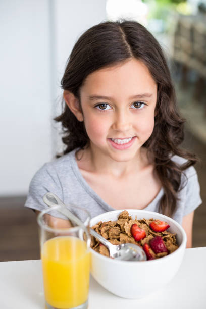 istock Smiling girl having breakfast 674424244