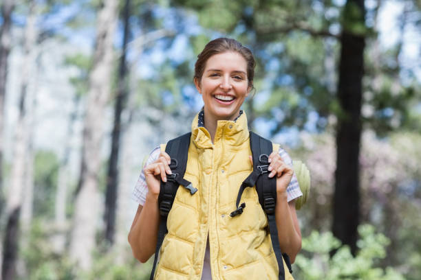istock Smiling young woman standing in forest 674426578