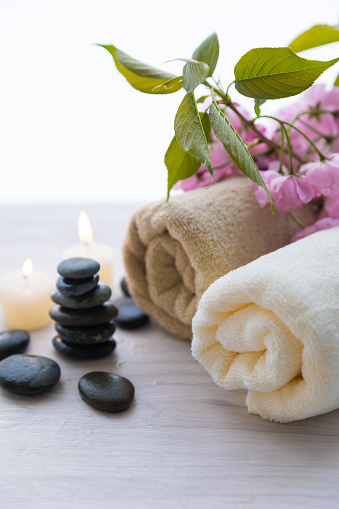 White flower jasmine and black stones on grey background.  Spa relax concept,  zen-like stones concept