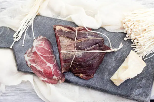 Aged meat on the cutting board with parmesan cheese and mashrooms