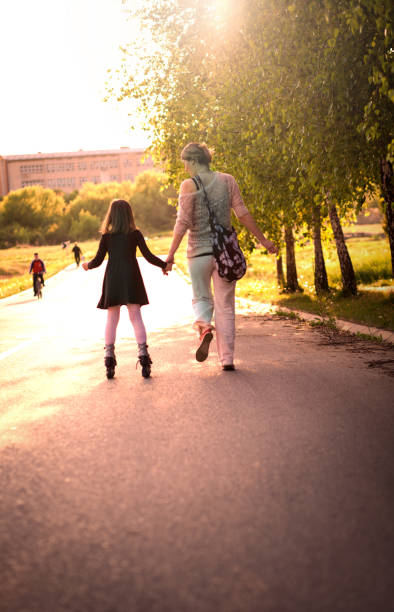 istock Mother helping little daugther to roller skate 674430392