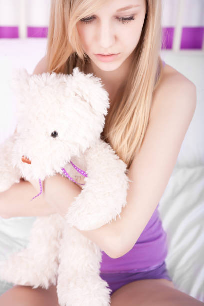 istock Sad young woman hugging teddybear 674434846