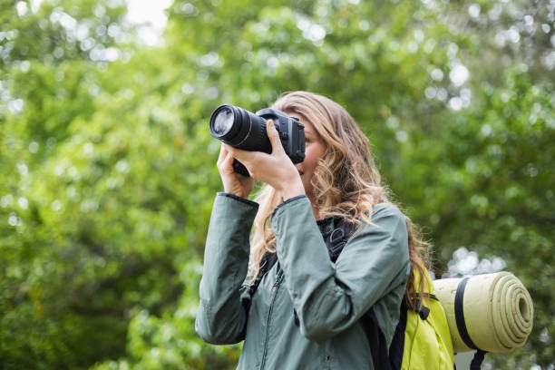 istock Low angle view of woman photographing with camera 674441182