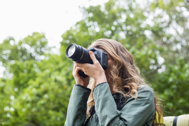 istock Low angle view of woman photographing with digital camera 674441212
