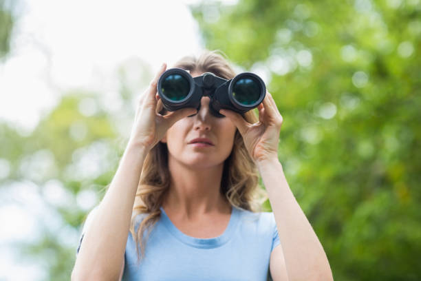 istock Close-up of woman looking through binocular 674441448