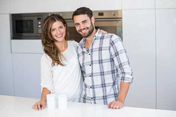 istock Happy young couple standing by table 674441584