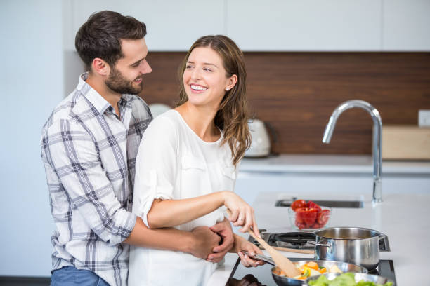 istock Happy man embracing woman while cooking food 674441728