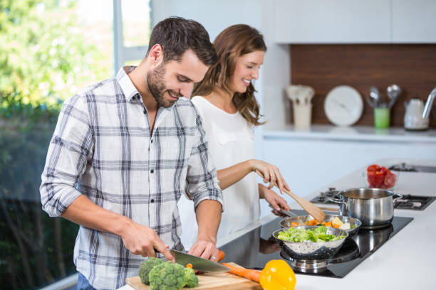 istock Couple preparing food at kitchen counter 674441752
