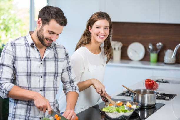 istock Couple preparing food in kitchen at home 674442568