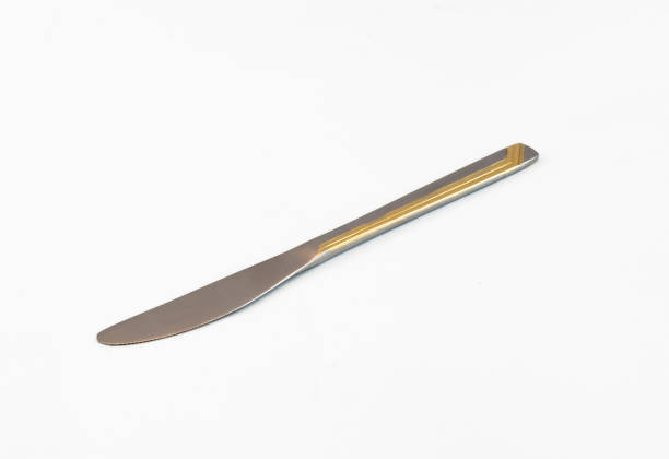 istock Silver table knife with gilded stripes on handle on a white background 674447180