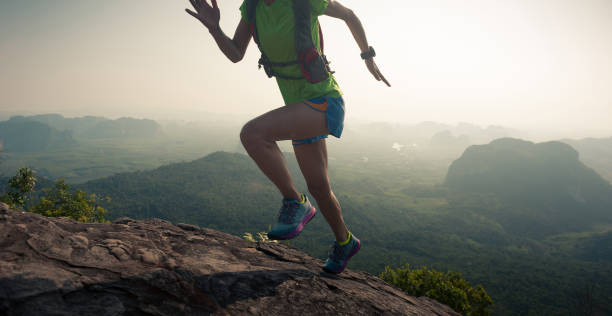 istock young woman trial runner running up on mountain top 674448406