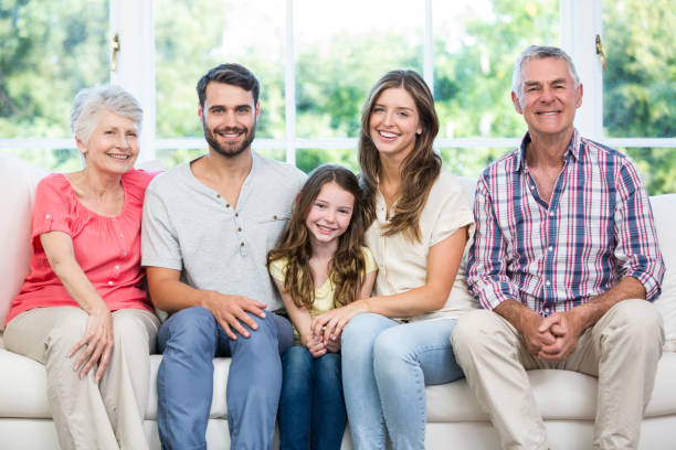 istock Happy family sitting on sofa at home 674448980