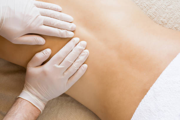 istock Therapist hands in protective gloves massaging woman's back. 674453614