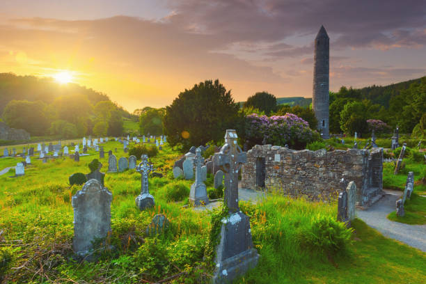 der runde turm und der friedhof am glendalough klösterlichen standort im land wicklow, irland - irish cross stock-fotos und bilder