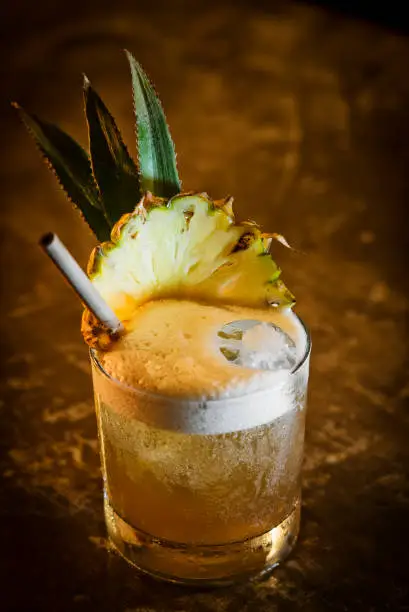 Photo of pineapple mango tropical rum fruity cocktail drink in bar