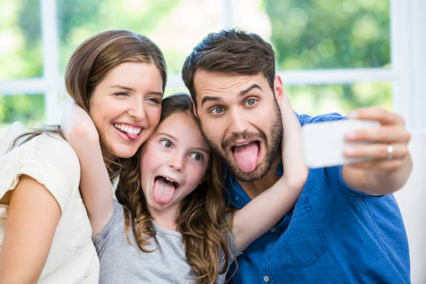 istock Happy family making faces while clicking selfie 674463608