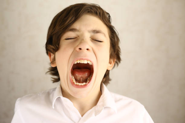 istock teenager boy yawning open mouth 674486128
