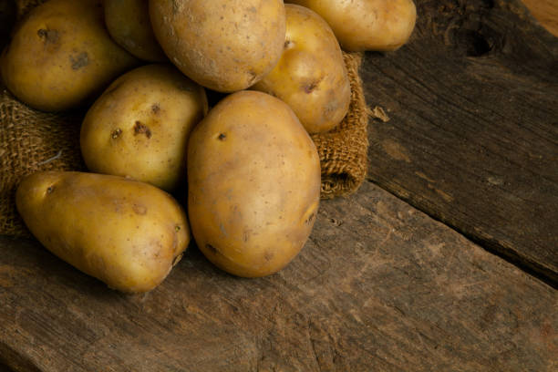 istock Pile of potatoes on wooden table 674494048