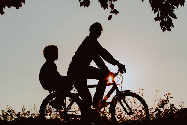 istock father with son riding bikes at sunset 674497386