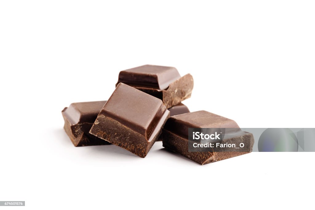 Pieces of bitter, dark chocolate bar, cubes on heap, isolated on white background, close-up view Pieces of bitter, dark chocolate bar, cubes on heap, isolated on white background, close-up view. Chocolate Stock Photo