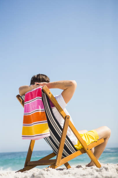 istock Man sitting and relaxing on deck chair 674504704
