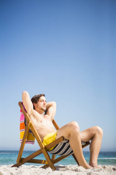 istock Man sitting and relaxing on deck chair 674504774