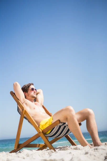 istock Man sitting and relaxing on deck chair 674504918
