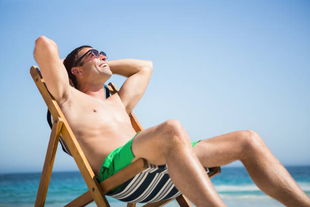 istock Man sitting and relaxing on deck chair 674504982